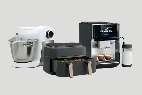 Küchenmaschine, Heißluftfritteuse mit Gemüse und Kaffeevollautomat mit zwei Espressotassen nebeneinander