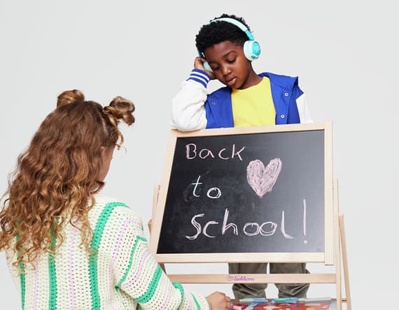 Back to School – Mädchen mit geflochtenen Haaren und Junge mit Kopfhörern an einer Tafel mit Kreidezeichnung