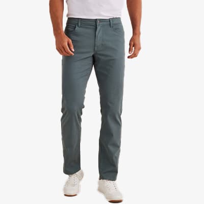 Person trägt graue Hose, weißes T-Shirt und weiße Schuhe, Ansicht von vorne