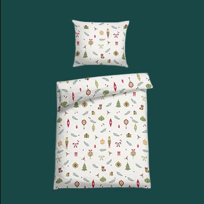 Weißes Bettwäsche-Set mit Weihnachtsmotiven wie Bäumen, Ornamenten und Geschenken auf dunkelgrünem Hintergrund