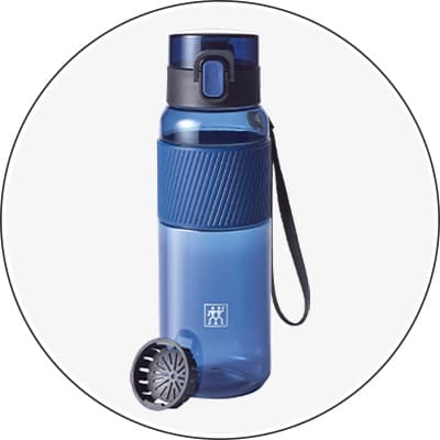 Blaue Trinkflasche mit Deckel und Griffband, daneben ein geöffnetes Sieb.