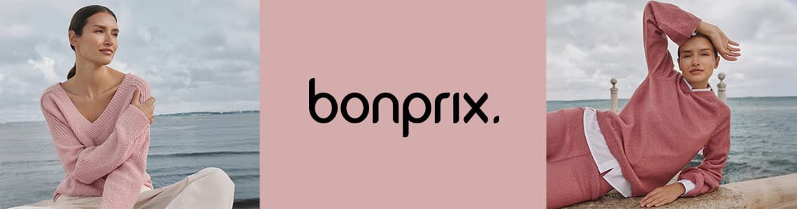 bonprix – Frau in rosa Pullover am Meer, Frau in rosa Pullover und Hose auf Steinmauer liegend