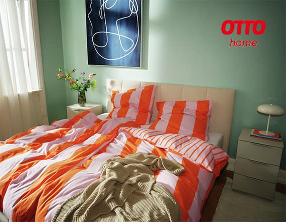 OTTO home – gemütliches Schlafzimmer mit orange-weiß gestreifter Bettwäsche und Blumen auf dem Nachttisch.