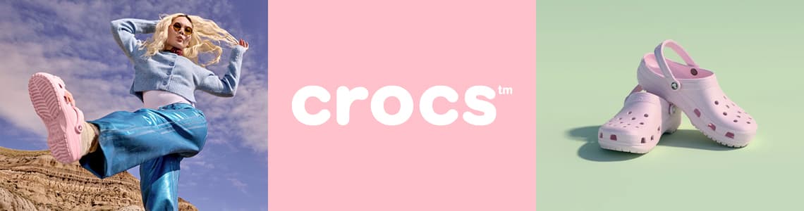 Crocs – Person in blauer Hose und grauem Pullover springt, rosa Crocs neben Schriftzug