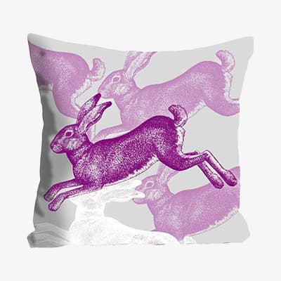 Lila Kissen mit springenden Hasen im Pop-Art-Stil.