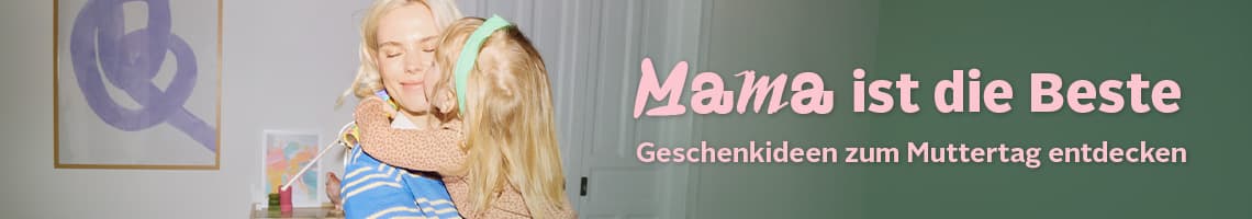 Mama ist die Beste – Geschenkideen zum Muttertag entdecken – Kind umarmt seine Mutter im Wohnzimmer