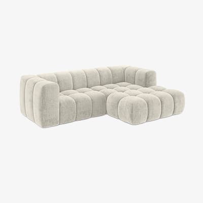 Ecksofa in hellem Beige mit breiten, gepolsterten Sitzflächen und markanten, würfelförmig abgesteppten Polstern