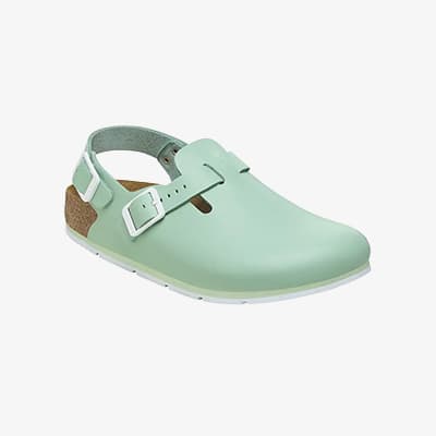 Hellgrüner Clog mit geschlossener Vorderkappe, Fersenriemen und weißer Schnalle vor hellem Hintergrund