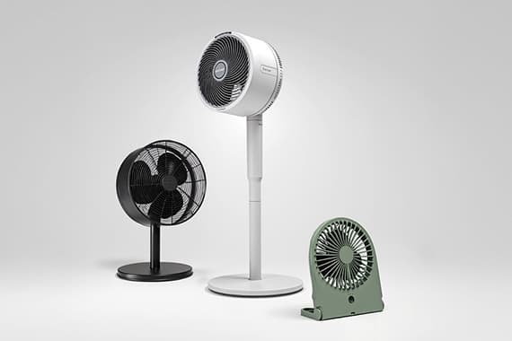 Drei Ventilatoren in Schwarz, Weiß und Grün in verschiedenen Größen stehen nebeneinander vor hellem Hintergrund