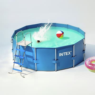 INTEX Rundpool mit Leiter, Kind taucht ins Wasser, bunte Strandball und Schwimmring treiben an der Wasseroberfläche