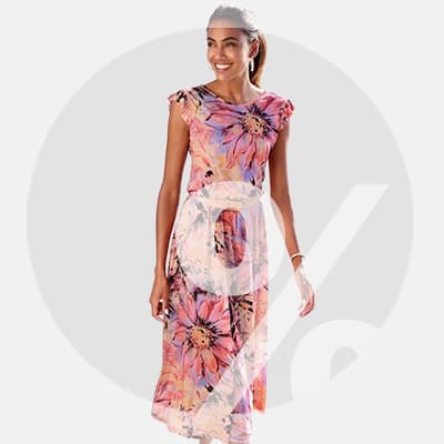 Frau in langem Kleid mit buntem Blumenmuster steht leicht seitlich und zeigt das Kleid von vorne