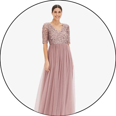 Frau trägt rosafarbenes Abendkleid mit Paillettenoberteil und Tüllrock.