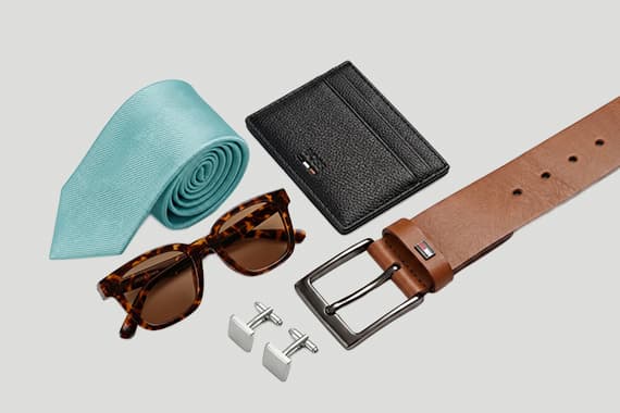 Herrenaccessoires im Set mit Krawatte, Sonnenbrille, Geldbörse, Gürtel und Manschettenknöpfen auf hellem Hintergrund