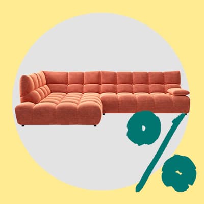 Ecksofa mit breiter Sitzfläche vor hellem Hintergrund, daneben grünes Prozentzeichen für Rabatt oder Angebot