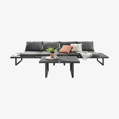 Gartenlounge mit grauen Polstern, Couchtisch davor mit Pflanze, Glas und Deko-Kissen auf der Sitzfläche