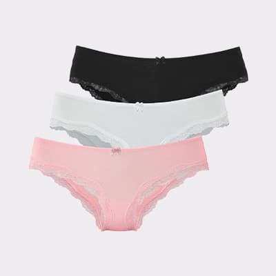 Dreierpack Damen-Slips mit Spitze in Schwarz, Weiß und Rosa, gestapelt vor hellem Hintergrund