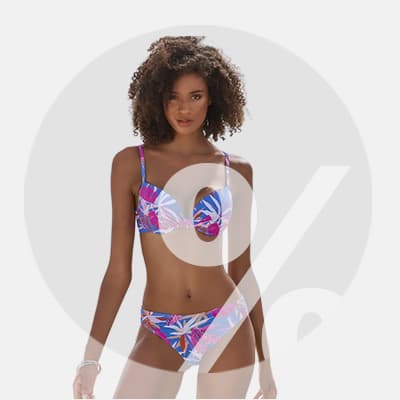 Frau in buntem Bikini mit Blumenmuster, steht vor grauem Hintergrund.